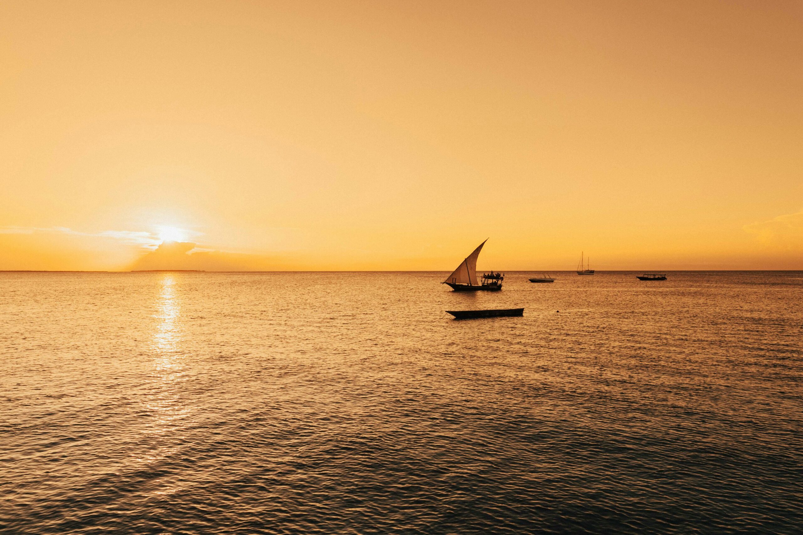 Zanzibar Serene sailboat scene with a golden sunset over the Indian Ocean in Zanzibar, Tanzania.